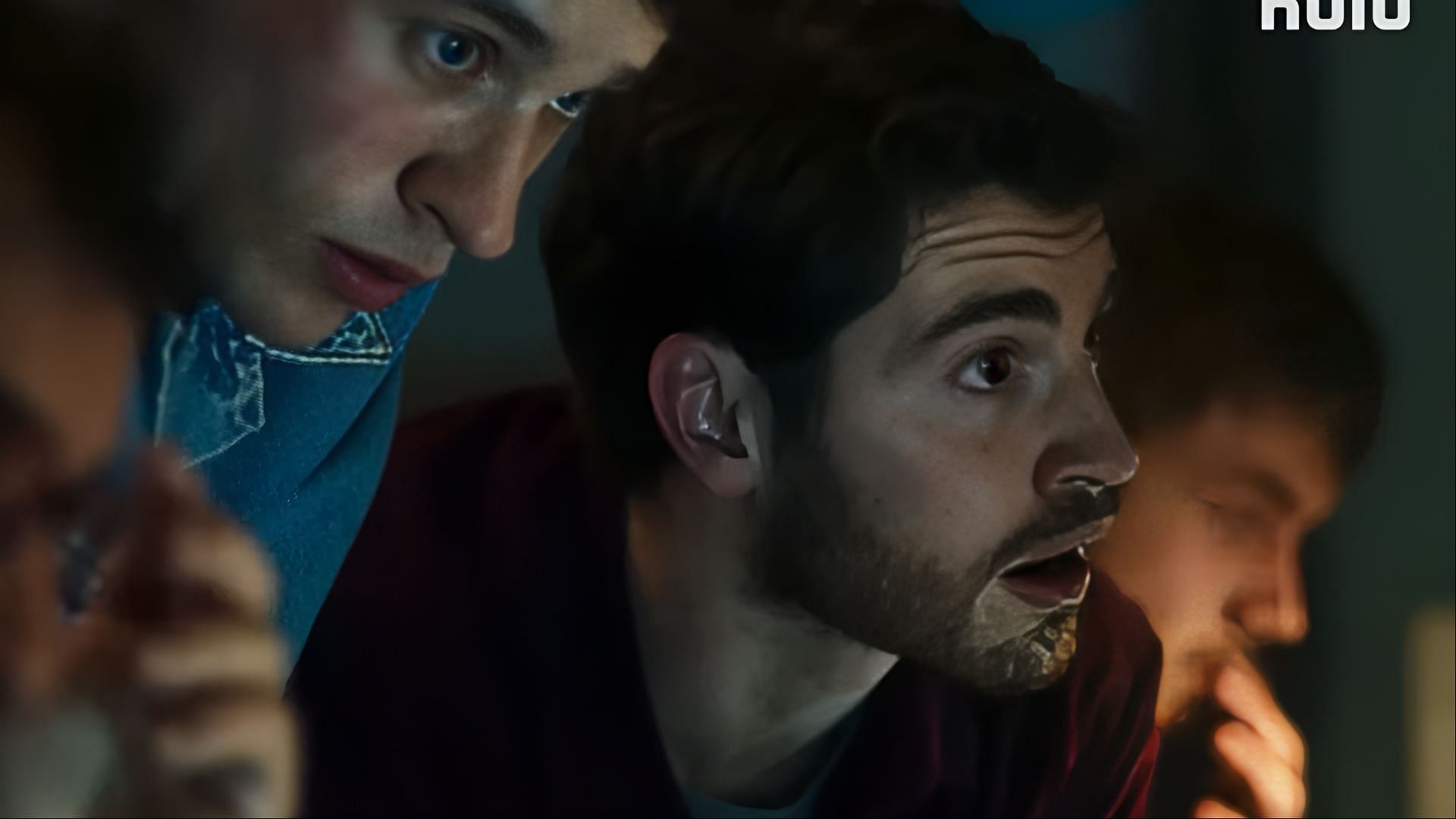 Felix Mayr as a member of the journalist collective leads a tense moment of analysis alongside fellow investigators. (Image via Hulu)